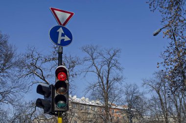 Trafik ışığı güzel mavi gökyüzü ile arka planda, Sofia kış çatı ve ağaç dal üzerinde kırmızı renk