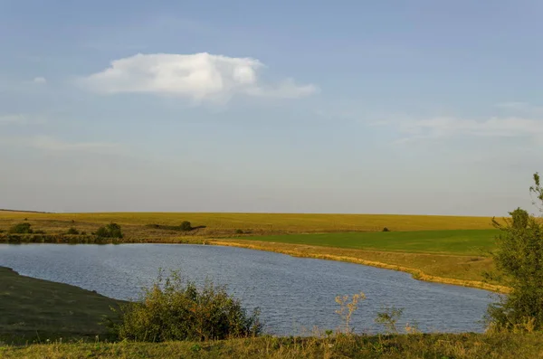 Malebná krajina s výhledem na jezero v podzimní pole — Stock fotografie