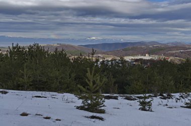 Bulutlu gökyüzü, kış dağ, karlı glade, bir yerleşim bölgesinde, kozalaklı ve Plana dağ Balkan dağ veya Stara planina, Bulgaristan, Europe doğru yaprak döken orman görkemli görünümü 