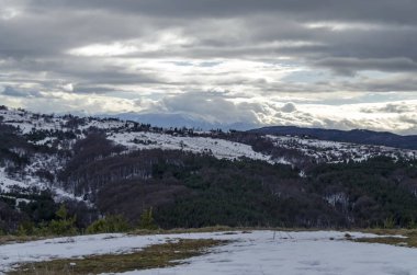 Bulutlu gökyüzü, kış dağ, karlı glade, bir yerleşim bölgesinde, kozalaklı ve Plana dağ Rila Dağı, Bulgaristan, Europe doğru yaprak döken orman görkemli görünümü 