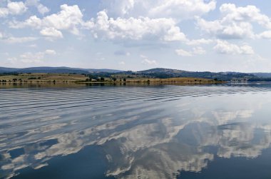 Natural reflection on Vlasina Mountain Lake and beautiful cloudy sky, Southeastern Serbia, Europe 