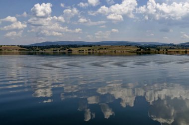 Natural reflection on Vlasina Mountain Lake and beautiful cloudy sky, Southeastern Serbia, Europe 