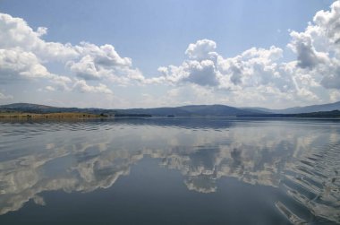 Natural reflection on Vlasina Mountain Lake and beautiful cloudy sky, Southeastern Serbia, Europe 