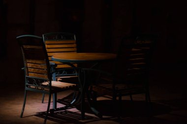 Geceleri sokakta bir kafede sandalyeli bir masa..