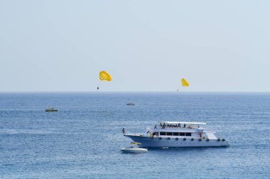 Turistler paraşütle denizde uçar..