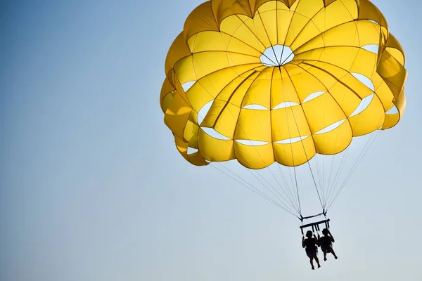 Bir Çift Aşık Gün Batımında Denizin Üzerinde Paraşütle Uçuyor — Stok fotoğraf