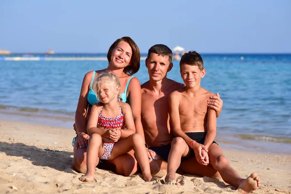 Kumsalda iki çocuklu mutlu bir aile..