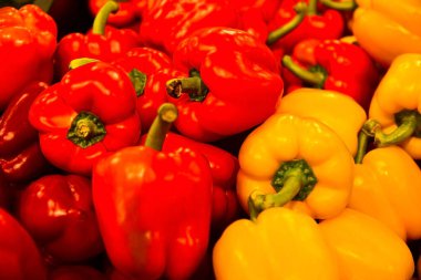 Kırmızı ve sarı biberler bir rafta yatıyor..