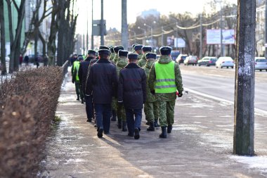 Military and police walk on the sidewalk in Minsk. clipart