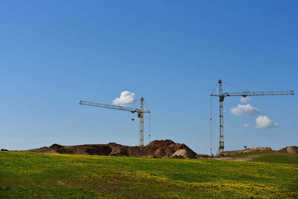 High-altitude cranes build a new house in the field.