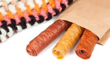 Şekerlenmiş meyve içinde bükülmüş beyaz arka plan üzerinde izole kese kağıdı rulo. Ev yapımı kurutulmuş meyve tatlılık.