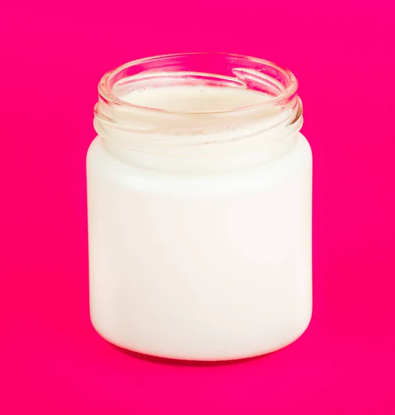 Jar with yogurt isolated on pink background. — Stock Photo, Image