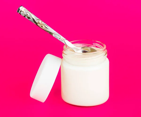 Jar with yogurt isolated on pink background. — Stock Photo, Image