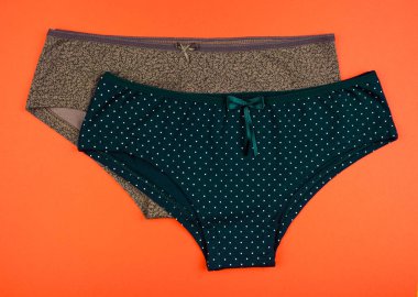 Kadın Pamuk külot üzerinde yalıtılmış turuncu arka plana çiçekli.