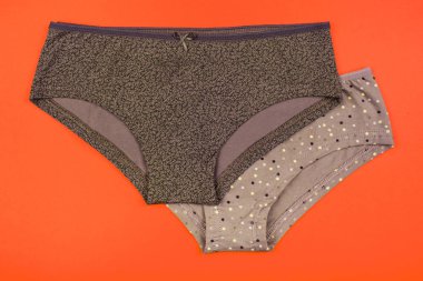 Kadın Pamuk külot üzerinde yalıtılmış turuncu arka plana çiçekli.