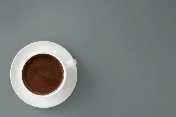 Kaffee in weißer Tasse auf grauem Hintergrund. Stockbild