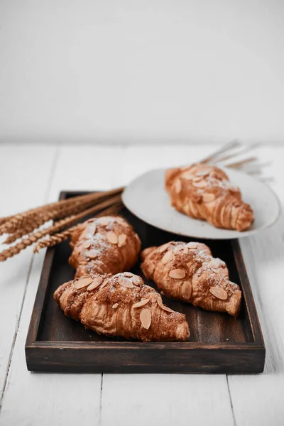 Croissant de almendras con relleno de crema sobre fondo de madera . — Foto de Stock