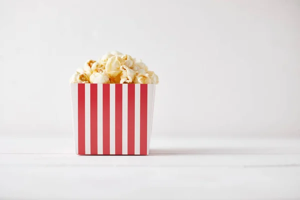 Full of tasty caramel popcorn in classic striped box