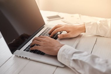 Genç adam laptopunda boş fotokopi ekranıyla çalışıyor.