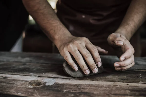 Handwerkerhände aus nächster Nähe, kneten und befeuchten den Ton. — Stockfoto