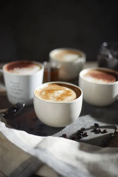 Xícara de café quente e grãos de café na mesa de madeira — Fotografia de Stock