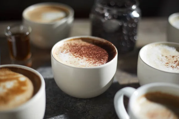 Taza de café caliente y granos de café en mesa de madera — Foto de Stock