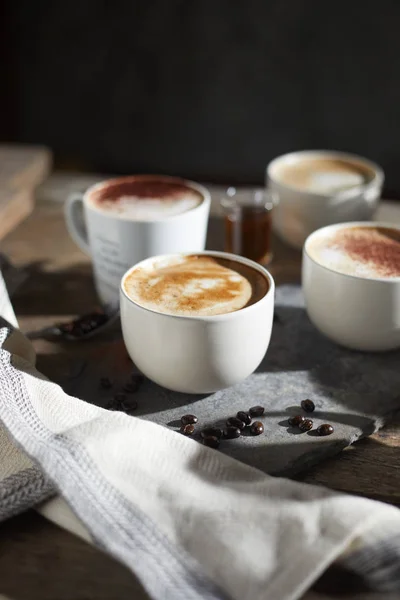 Xícara de café quente e grãos de café na mesa de madeira — Fotografia de Stock