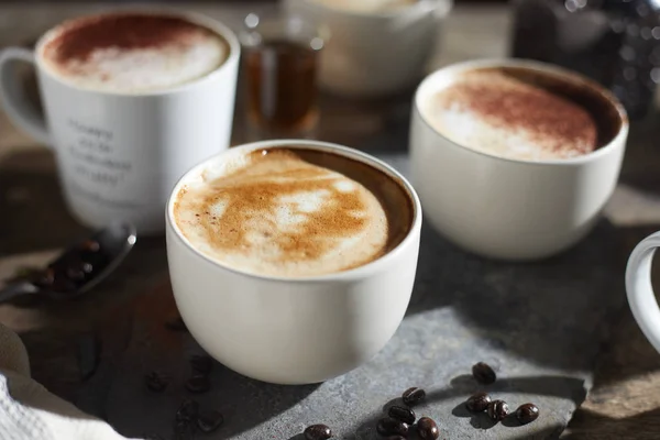 Taza de café caliente y granos de café en mesa de madera — Foto de Stock