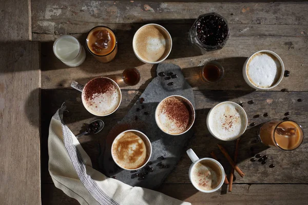 Xícara de café quente e grãos de café na mesa de madeira — Fotografia de Stock