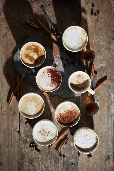 Xícara de café quente e grãos de café na mesa de madeira — Fotografia de Stock