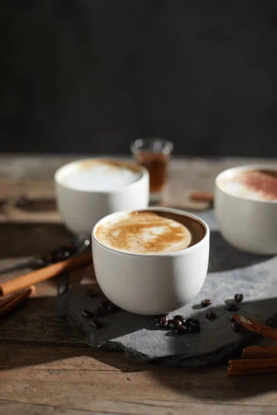 Warm kopje koffie en koffiebonen op houten tafel — Stockfoto