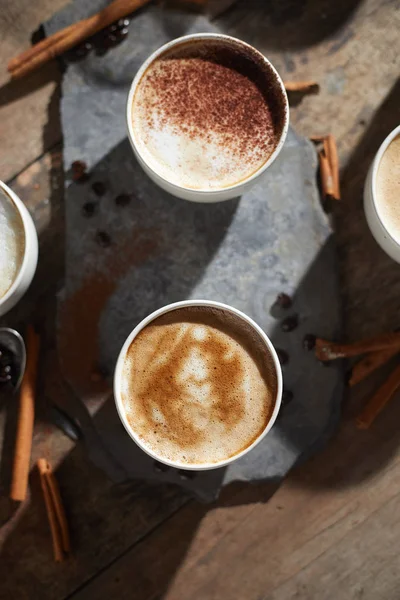 Taza de café caliente y granos de café en mesa de madera — Foto de Stock