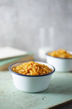 Arka planda mısır gevreği olan bir kase