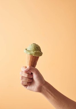 Elinde yeşil çay külahı olan bir dondurma.