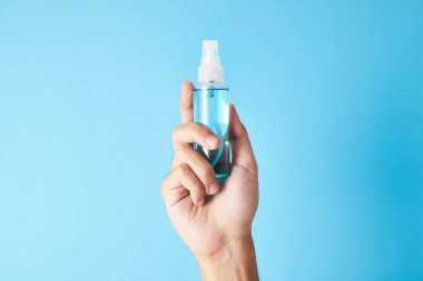 Kapalı bir şişe mavi alkol el spreyi. Corona virüsü onaylıyor