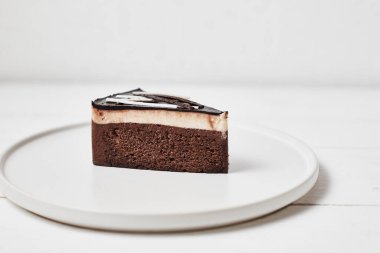 Masanın üzerinde bir dilim ev yapımı çikolatalı pasta.