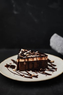 Masanın üzerinde bir dilim ev yapımı çikolatalı pasta.