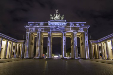 Günbatımı sırasında Berlin'de ışıklı Brandenburg Kapısı (Brandenburger Tor)