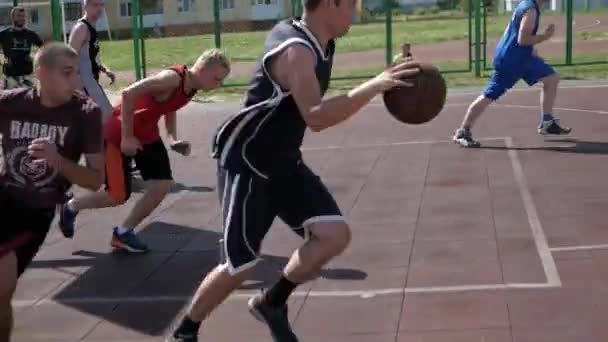 Bobrisk,ベラルーシ- 12 8月2019:スローモーション.ストリートバスケットボール選手ドリブルと防衛ボール。バスケットにボールを投げる — ストック動画