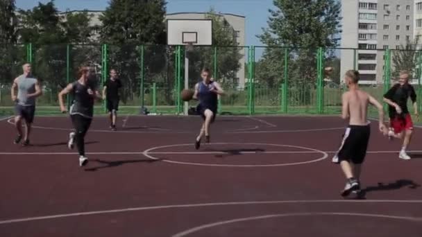 Bobruisk, Belarus - 12 augustus 2019: slow motion. Goed zicht. Knappe basketbalspeler vangt een bal, gooit hem hoog in de mand — Stockvideo