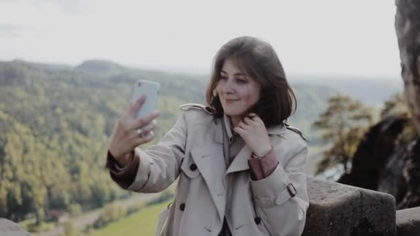 Portrait of happy young girl taking photo of herself on top of the mountain. Bastei. Saxon Switzerland National Park — Stock Video