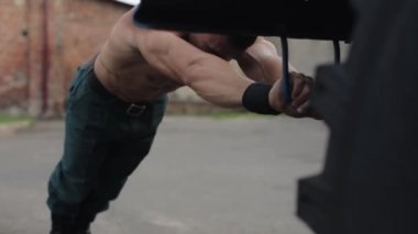 Yakışıklı kaslı adamın itfaiye arabasının yanında şınav çekişini yakından çek.