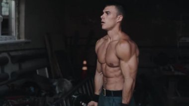 Spor salonunda halter kaldıran güçlü bir sporcunun yan görünüşü