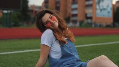 Genç hippi kızın çılgın suratlar ve ördek suratı yapan renkli şehir portresini kapatın. Muhteşem bir gülümseme, parlak makyaj, uzun saçlar.