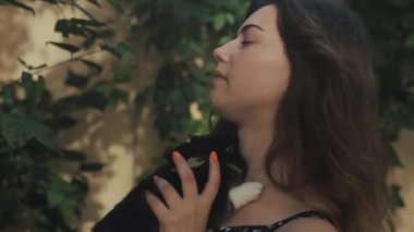 Genç ve güzel bir kadının küçük sevimli bir tavşanı öperkenki görüntüsü.