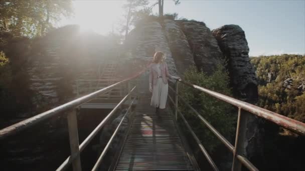 En cámara lenta. Feliz joven mujer caminando por un largo sendero de acero y disfrutando de la vista de las montañas — Vídeo de stock