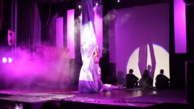 Moskova, Rusya - 5 Ağustos 2018: dans gösterisi. Genç, güzel bayan akrobat sahnede beyaz ipeklerle akrobatik numaralar yapıyor.