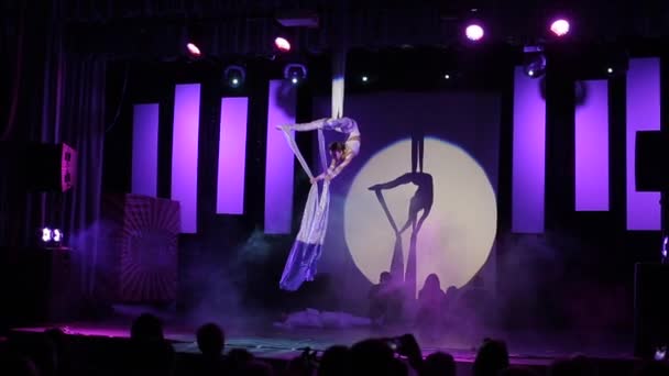 Moscú, Rusia - 5 de agosto de 2018: Danza espectáculo. Joven hermosa acróbata hembra haciendo trucos acrobáticos en sedas aéreas blancas en el escenario — Vídeo de stock