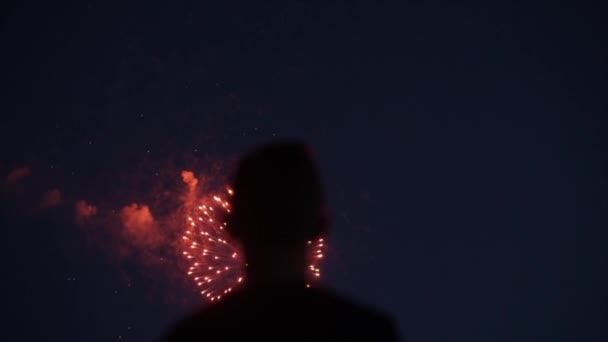 Θολή σιλουέτα από κοντινό πλάνο ενός άντρα που απολαμβάνει πυροτεχνήματα τη νύχτα. — Αρχείο Βίντεο