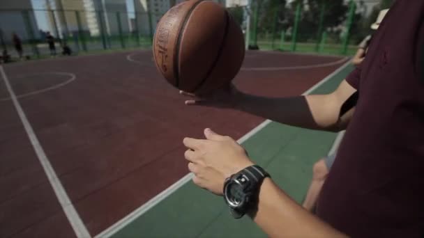 Bobruisk, Bielorrússia - 12 de agosto de 2019: Close-up. Jovem jogador de basquete saltando bola no campo de basquete ao ar livre — Vídeo de Stock